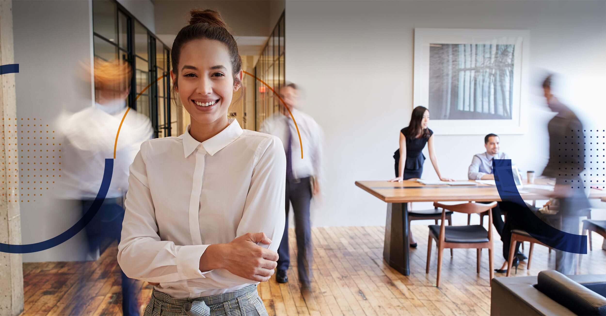 A business owner standing in her office as her team works behind her